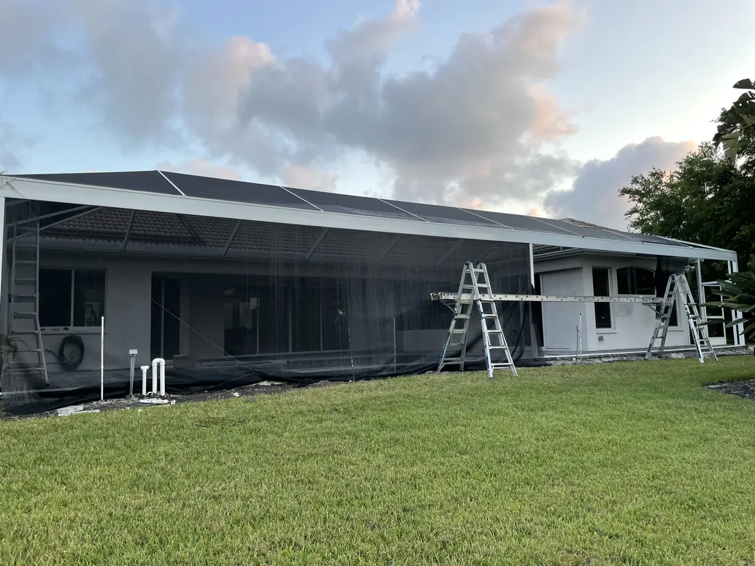 Pool cage replacement in progress on a Florida home, with the old frame partly removed
