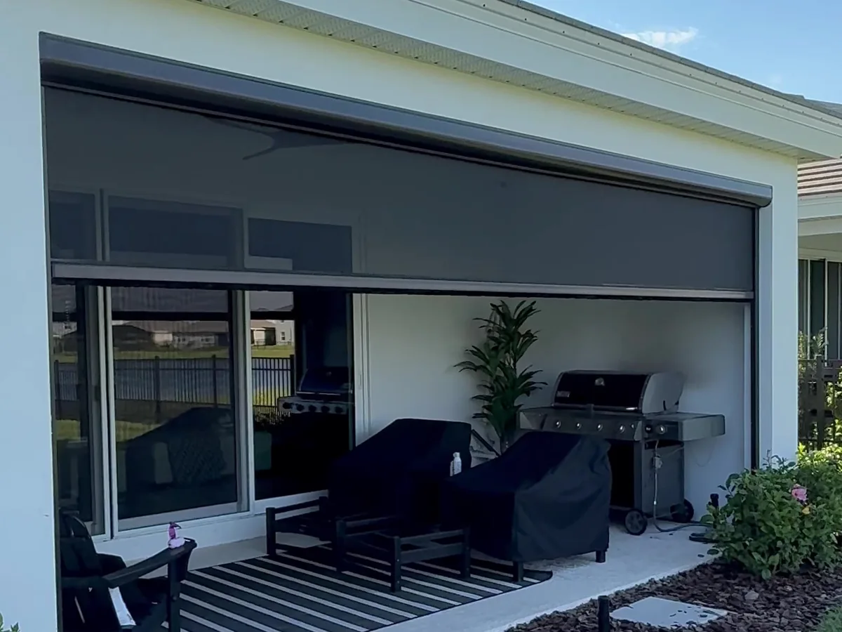 Motorized retractable screen lowering across a covered porch opening in Sarasota