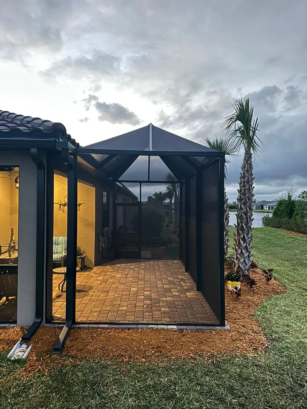 Restored and repainted bronze pool cage frame on a Florida home at dusk