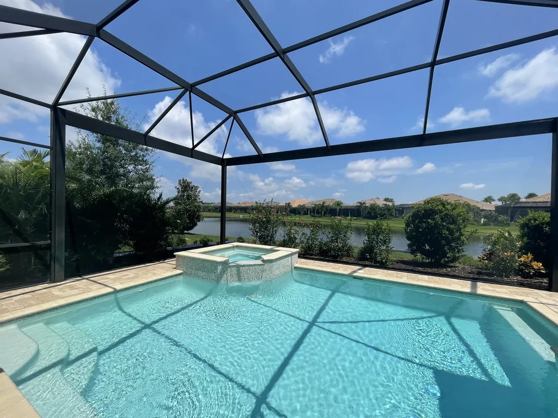 Freshly rescreened pool cage with new screen panels above a pool and spa in Sarasota