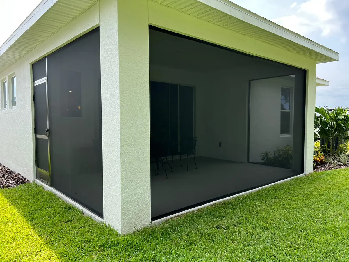 Newly screened lanai room on the side of a Florida house with fresh landscaping