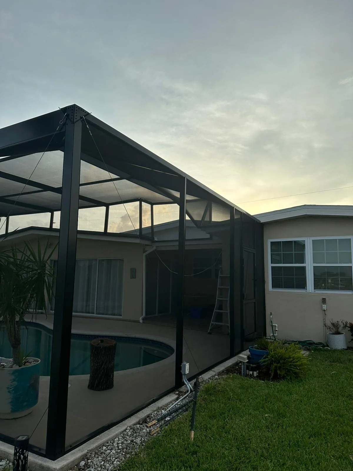 Bronze frame pool cage after a complete rescreen with new screen panels